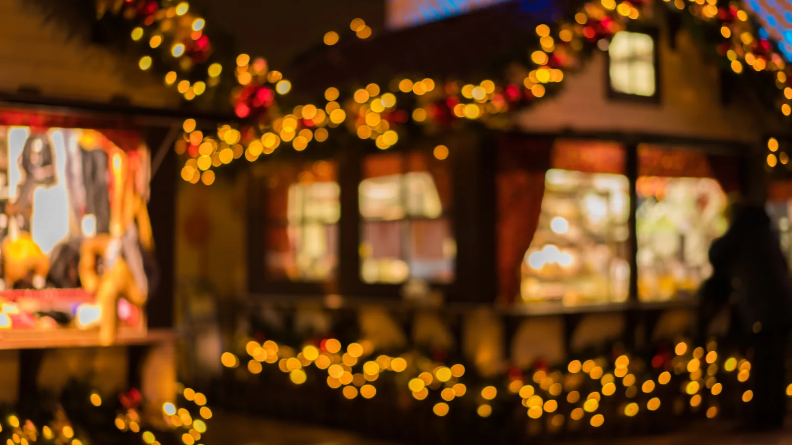 Chalets d'un marché de Noël illuminés à la tombée de la nuit